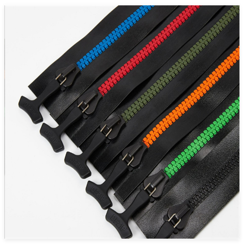 A set of colorful black zippers with blue, red, orange, and green coils, each featuring a black puller