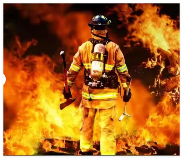 A firefighter wearing protective gear standing in front of a raging fire, symbolizing fire safety