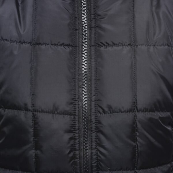 A close - up of a silver - toothed zipper on a black quilted jacket fabric