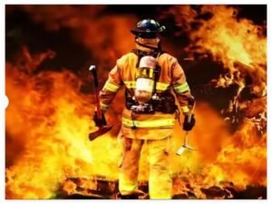 A firefighter wearing protective gear standing in front of a raging fire, symbolizing fire safety