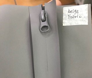Matte grey sealed waterproof zipper sample matched with beige fabric, custom puller for technical textile